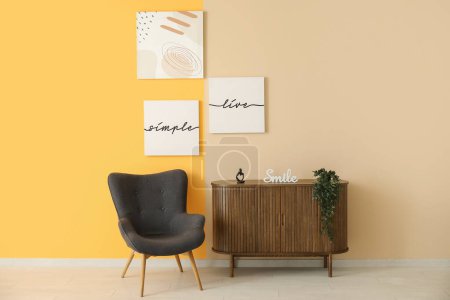 Téléchargez les photos : Fauteuil gris et armoire en bois près du mur coloré avec différentes peintures - en image libre de droit
