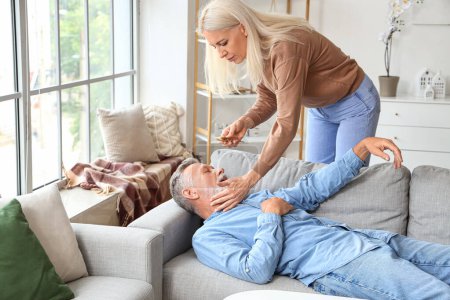 Photo for Mature woman and her husband having heart attack at home - Royalty Free Image