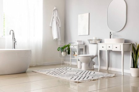 Intérieur des toilettes lumineuses avec cuvette de toilette en céramique, baignoire et vanités