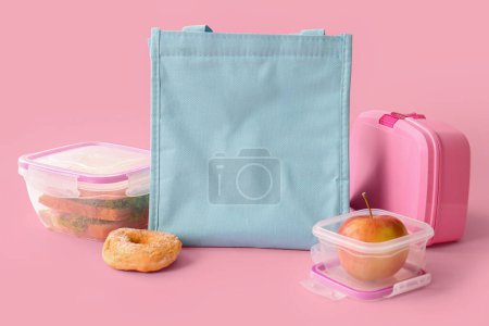 Téléchargez les photos : Sac et boîtes à lunch avec de délicieux aliments sur fond rose - en image libre de droit