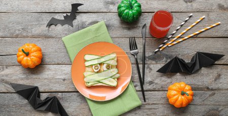 Lustiges Halloween-Essen für Kinder auf Holz-Hintergrund