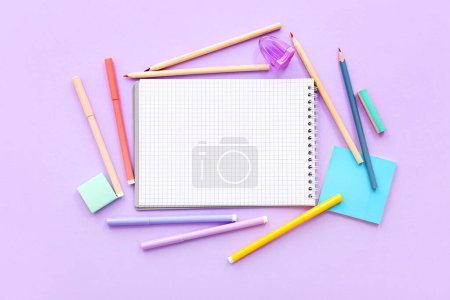 Téléchargez les photos : Composition avec carnet vierge et fournitures scolaires sur fond lilas - en image libre de droit