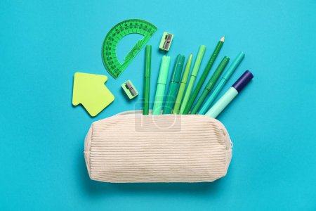 Téléchargez les photos : Étui à crayons avec différentes papeterie scolaire sur fond turquoise - en image libre de droit