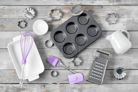 Foto de Set de utensilios de cocina y bandeja para hornear sobre mesa de madera - Imagen libre de derechos