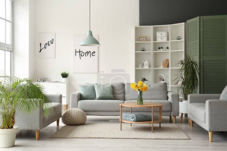 Foto de Interior de la moderna sala de estar con sofás grises y florero en la mesa de café - Imagen libre de derechos