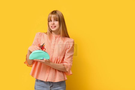 Photo for Female student with pencil case on yellow background - Royalty Free Image