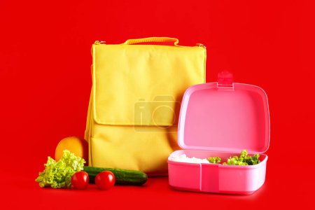 Téléchargez les photos : Sac et boîte à lunch avec des aliments savoureux sur fond rouge - en image libre de droit