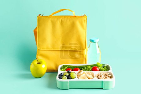 Téléchargez les photos : Sac, bouteille d'eau et lunchbox avec de la nourriture savoureuse sur fond turquoise - en image libre de droit