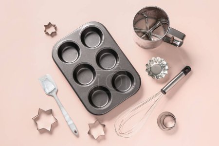 Baking form and utensils on beige background