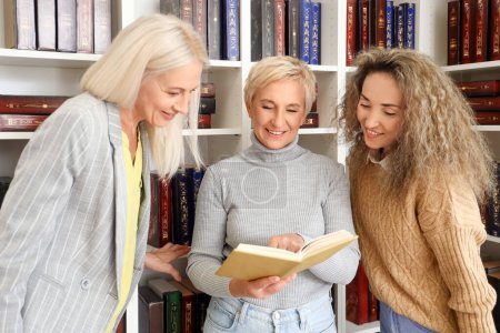 Mujeres maduras leyendo libro en casa biblioteca