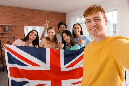 Young students with UK flag taking selfie at language school