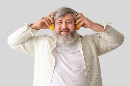 Foto de Retrato del hombre mayor en protectores auditivos sobre fondo gris. Fiesta del Día del Trabajo - Imagen libre de derechos