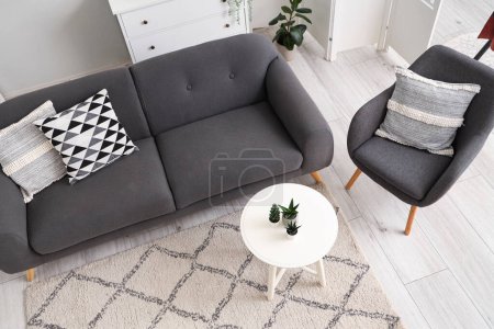 Photo for Interior of light living room with cozy armchair and grey sofa - Royalty Free Image