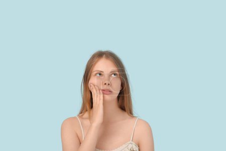 Téléchargez les photos : Jeune femme souffrant de mal de dents sur fond bleu - en image libre de droit