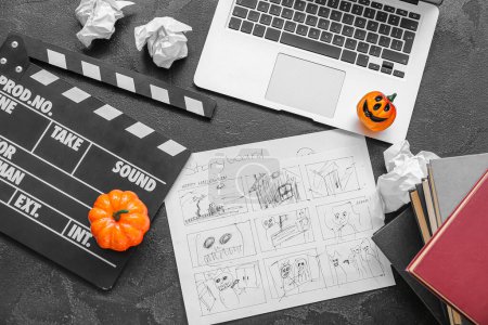 Photo for Laptop with clapperboard, storyboard and pumpkins on grunge grey background. Halloween celebration - Royalty Free Image