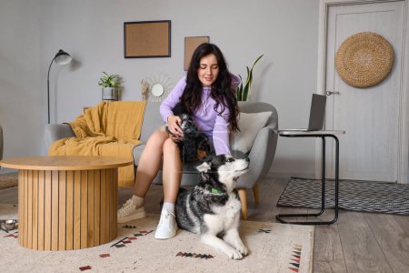 Foto de Mujer joven con perros lindos en casa - Imagen libre de derechos