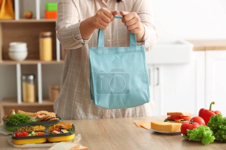 Téléchargez les photos : Mère avec sac de boîte à lunch pour l'école en cuisine - en image libre de droit