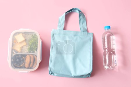 Téléchargez les photos : Sac, boîte à lunch avec de délicieux aliments et bouteille d'eau sur fond rose - en image libre de droit