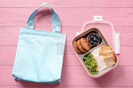 Téléchargez les photos : Sac et boîte à lunch avec de délicieux aliments sur fond de bois rose - en image libre de droit