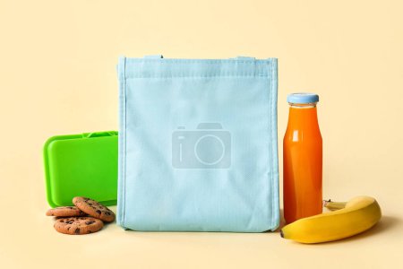 Téléchargez les photos : Sac, boîte à lunch avec de délicieux aliments et bouteille de jus sur fond jaune - en image libre de droit
