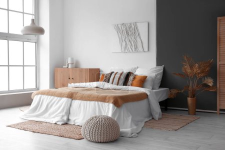 Photo for Interior of stylish bedroom with cozy bed and wooden cabinet - Royalty Free Image