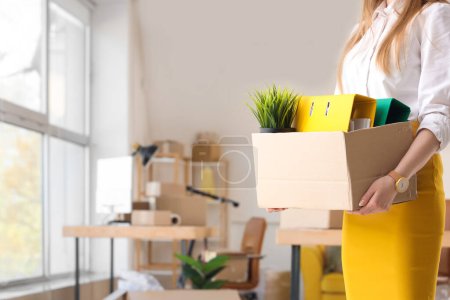 Téléchargez les photos : Femme d'affaires tenant boîte en carton avec des biens dans le bureau le jour du déménagement - en image libre de droit