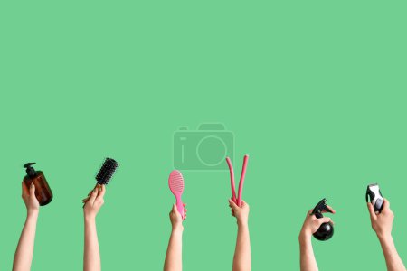 Téléchargez les photos : De nombreuses mains avec différentes fournitures de coiffure sur fond vert - en image libre de droit