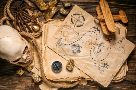 Human skull with treasure map, old manuscripts and golden nuggets on brown wooden background