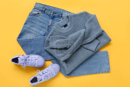 Stilvoller Kinderpullover, Jeans und Gummischuhe auf farbigem Hintergrund
