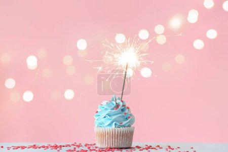 Photo for Tasty birthday cupcake with sparkler on color background - Royalty Free Image