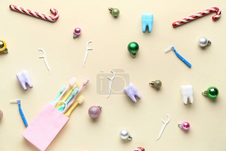 Foto de Bolsa con cepillos de dientes, hilo dental y juguetes de Navidad sobre fondo beige - Imagen libre de derechos