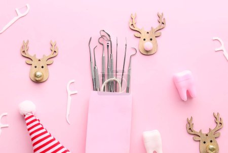 Foto de Bolsa con herramientas dentales y decoración navideña sobre fondo rosa - Imagen libre de derechos