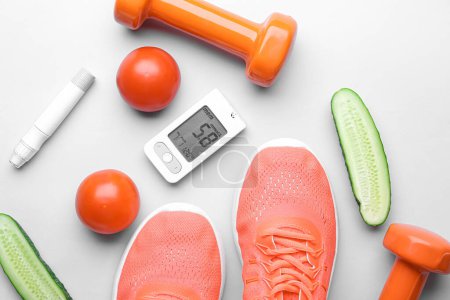 Photo for Glucometer with lancet pen, sneakers, dumbbells and vegetables on light background - Royalty Free Image
