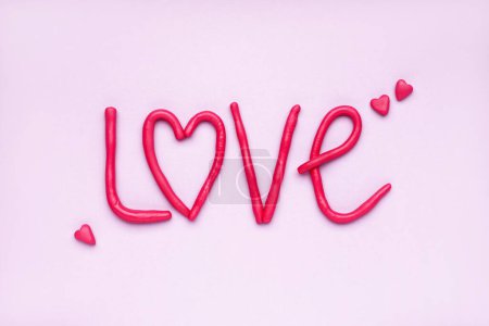 Photo for Word LOVE made of play dough on lilac background - Royalty Free Image
