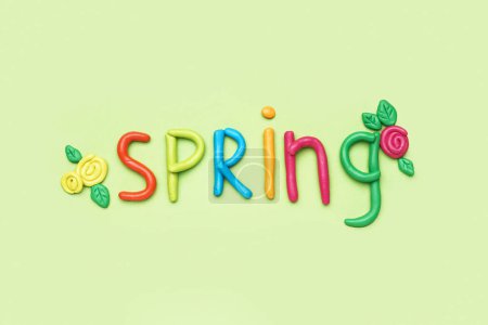 Photo for Word SPRING made of play dough on light green background - Royalty Free Image
