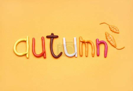 Photo for Word AUTUMN made of play dough on orange background - Royalty Free Image
