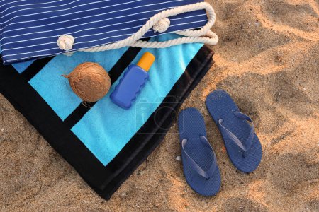 Foto de Chanclas elegantes con accesorios de playa y coco sobre arena en el resort - Imagen libre de derechos