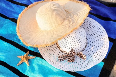 Téléchargez les photos : Chapeaux de paille élégants et étoiles de mer sur serviette colorée - en image libre de droit