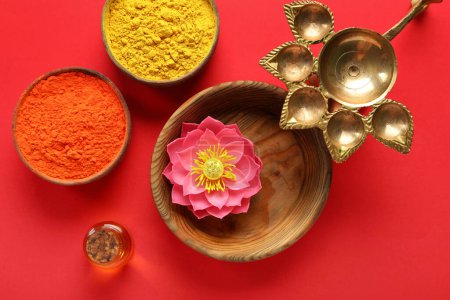 Photo for Diya lamp with aroma oil, lotus flower and bowls of colorful powder on red background. Divaly celebration - Royalty Free Image