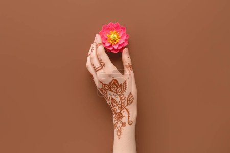 Photo for Female hand with lotus flower for celebration of Divaly on brown background - Royalty Free Image