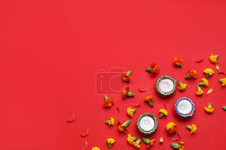 Photo for Burning candles with marigold flowers on red background. Divaly celebration - Royalty Free Image