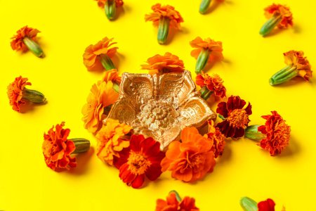 Photo for Diya lamp with marigold flowers on yellow background. Divaly celebration - Royalty Free Image