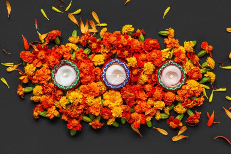 Photo for Burning candles with marigold flowers on black background. Divaly celebration - Royalty Free Image