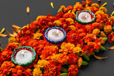 Photo for Burning candles with marigold flowers on black background. Divaly celebration - Royalty Free Image