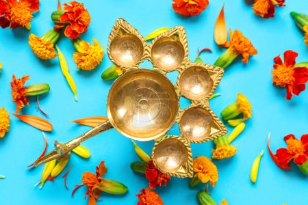 Photo for Diya lamp with marigold flowers on blue background. Divaly celebration - Royalty Free Image