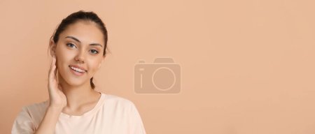 Téléchargez les photos : Jolie fille avec des appareils dentaires sur fond beige avec de l'espace pour le texte - en image libre de droit
