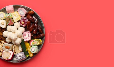 Photo for Plate with Indian treats on red background with space for text. Divaly celebration - Royalty Free Image
