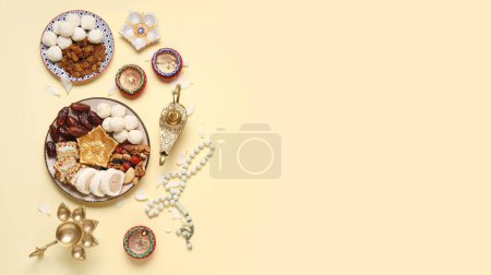 Photo for Plates with Indian treats and lamps on beige background with space for text. Divaly celebration - Royalty Free Image