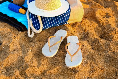 Foto de Chanclas con estilo con accesorios de playa en la arena en el resort - Imagen libre de derechos