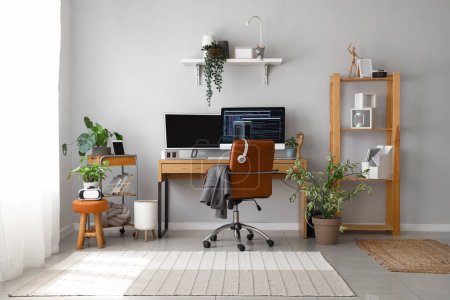 Innenraum eines hellen Büros mit Programmierarbeitsplatz und Zimmerpflanzen